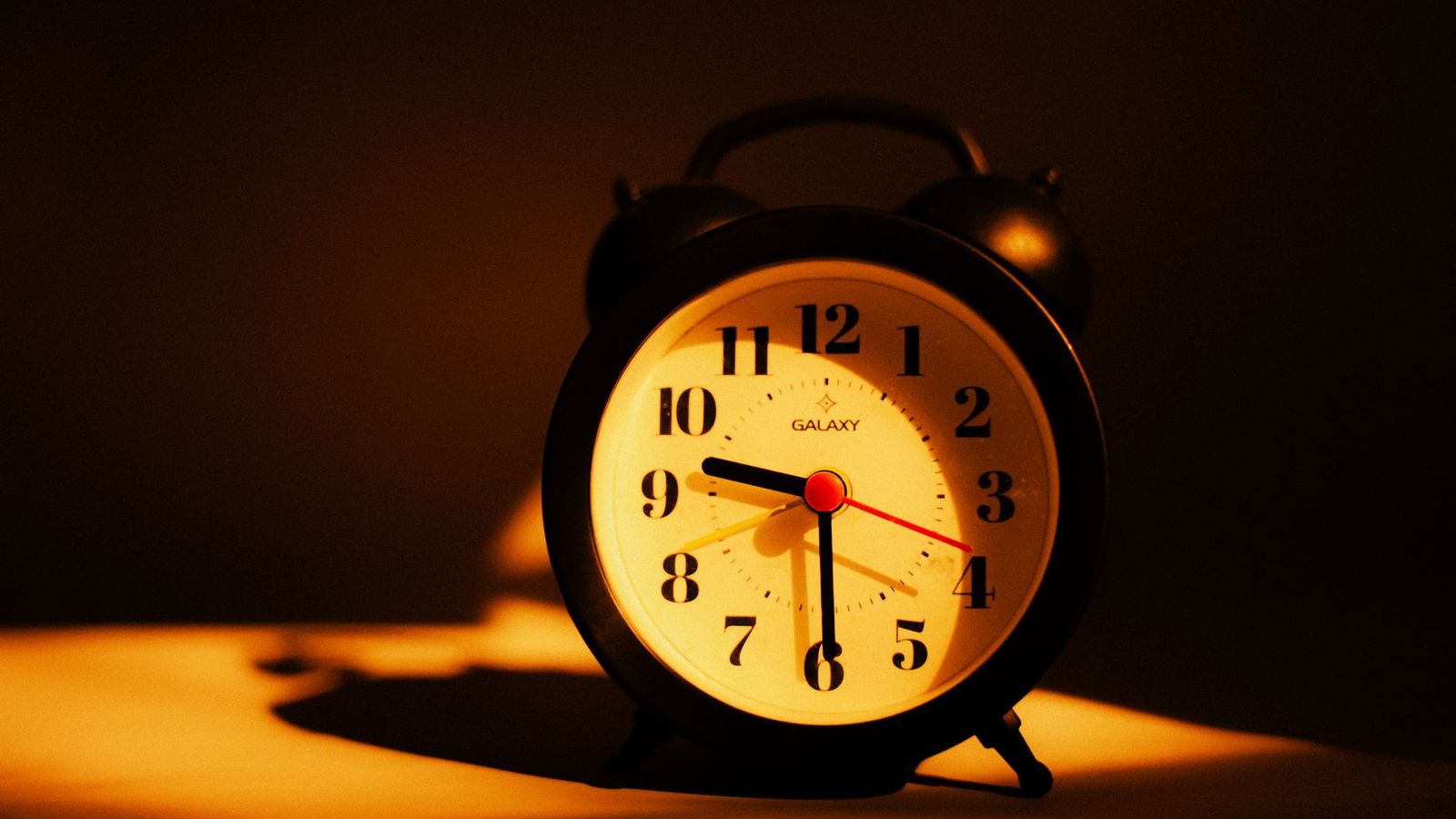 Wecker bei Nacht auf dem Nachttisch
